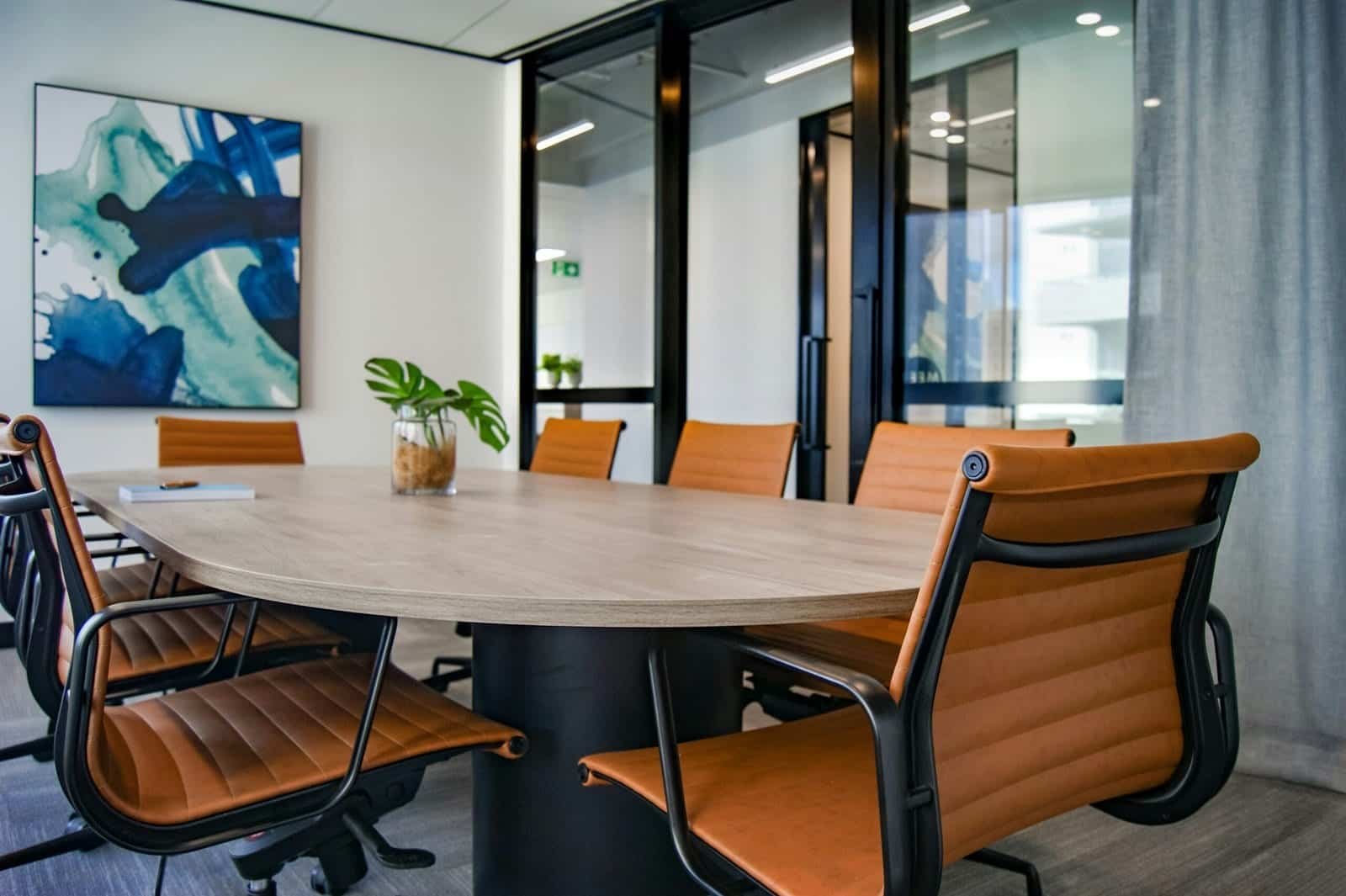 Office conference room with wooden table, leather chairs, and large windows for a professional works.